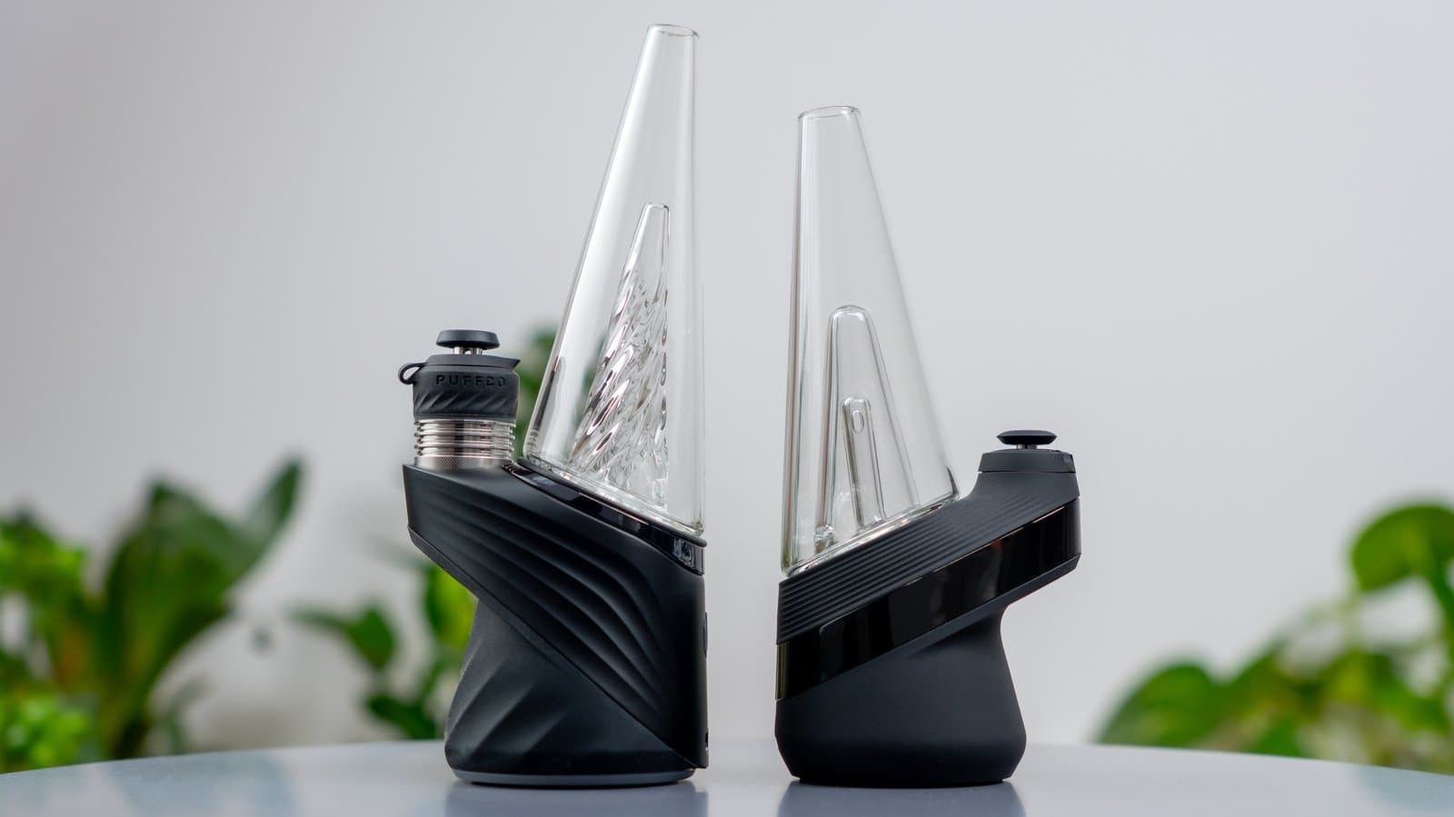 Puffco Peak Pro neben dem älteren Peak-Modell auf einem Tisch mit Pflanzen
