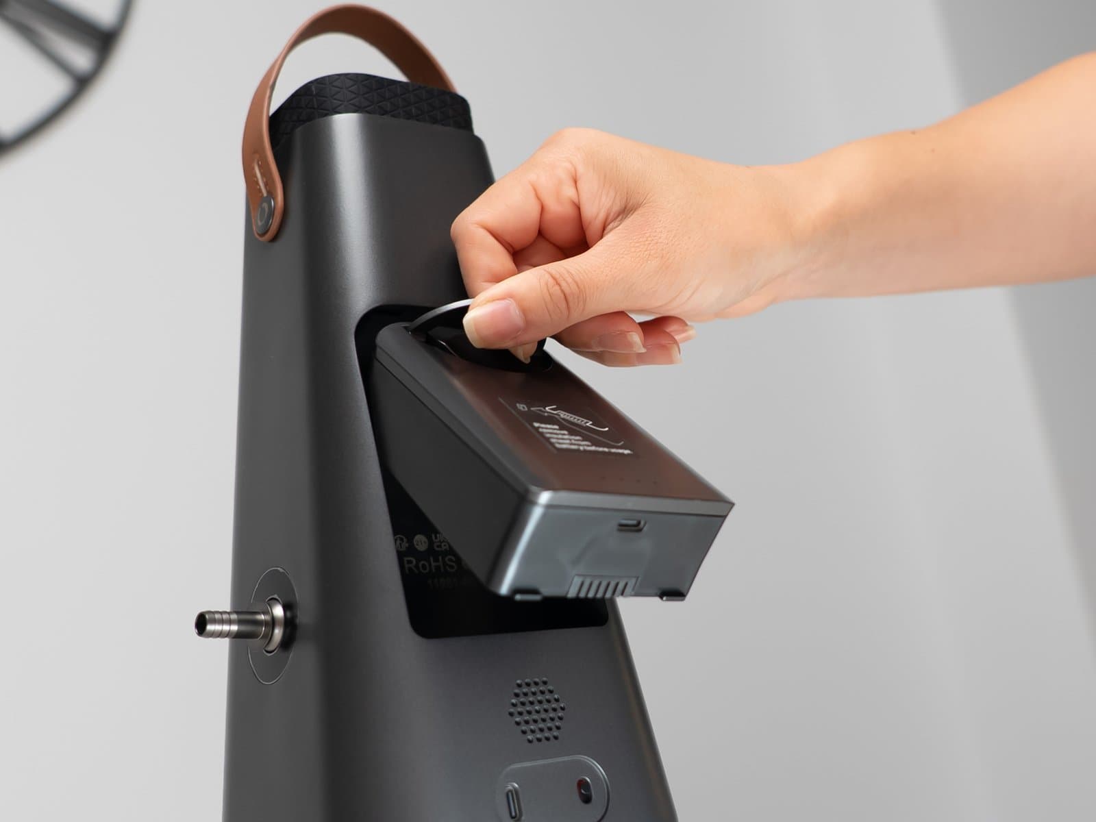 Hand zieht den Akkupack des AirVape Enso aus seinem Fach auf der Rückseite des Gehäuses