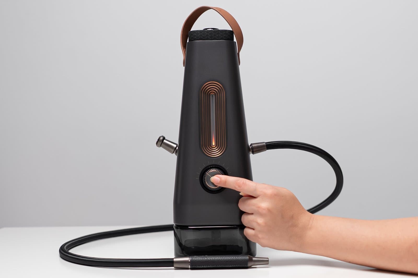 Finger pressing the AirVape Enso control dial as the light bar starts to glow
