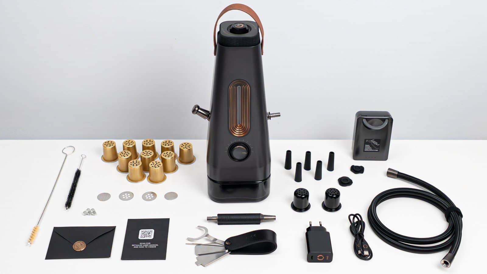 Ausgepacktes Komplettset des AirVape Enso mit Schalen, Schlauch, Akkupack, Bürsten und Zubehör auf weißer Fläche angeordnet