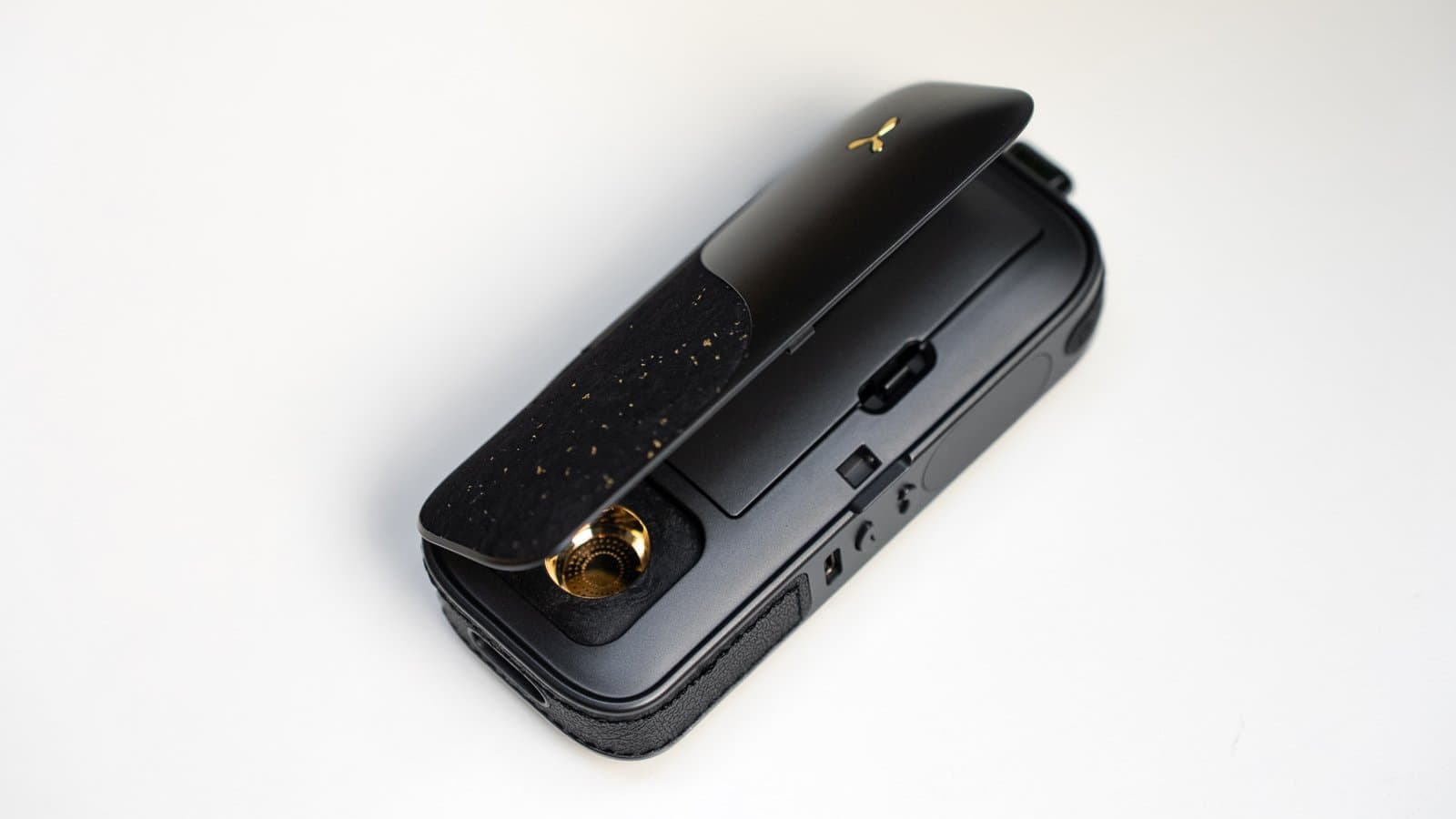 AirVape Legacy Pro 2 with clamshell open showing gold chamber, cork lid inner