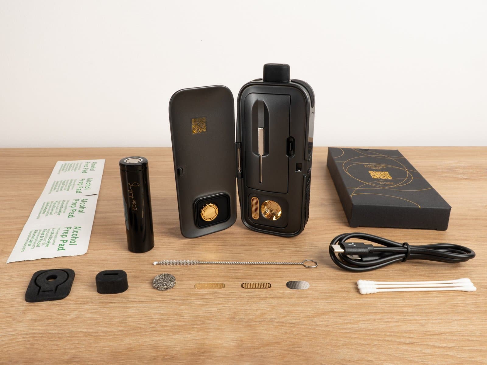 Flat lay of AirVape Legacy Pro 2 kit: battery, cable, brush, screens, prep pads