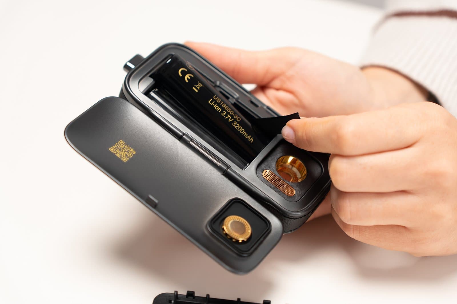 Hands removing 18650 battery from open AirVape Legacy Pro 2 compartment