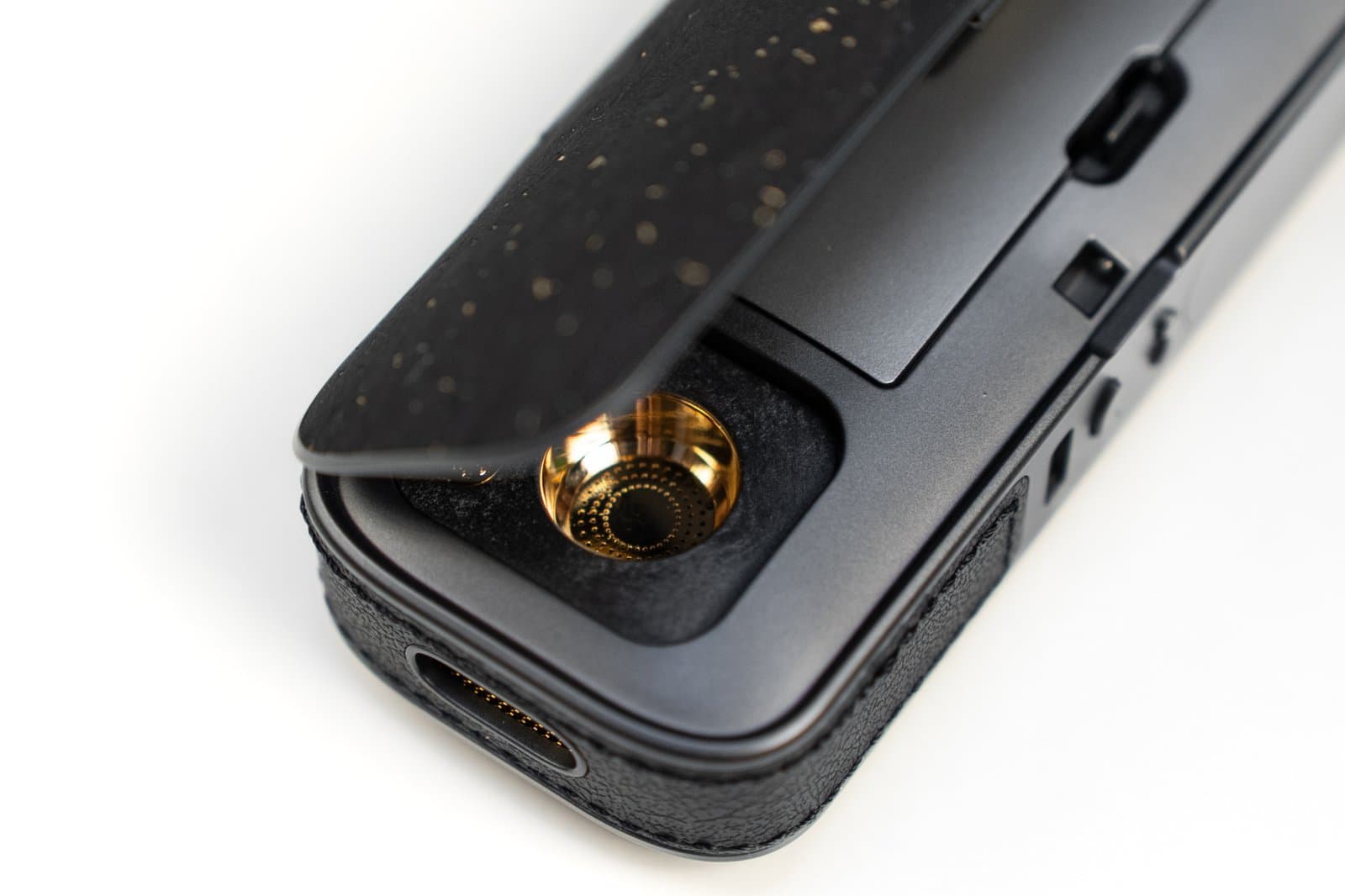 Macro of AirVape Legacy Pro 2 gold-plated chamber under lifted cork lid
