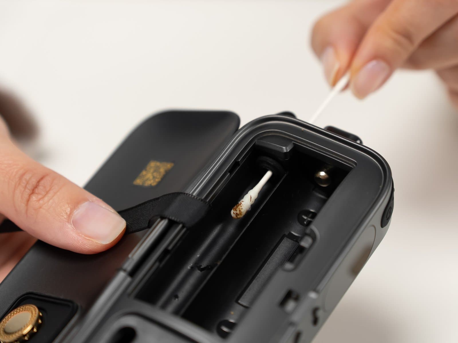 Luftweg des AirVape Legacy Pro 2 durch die geöffnete Reinigungsklappe mit einem Wattestäbchen reinigen