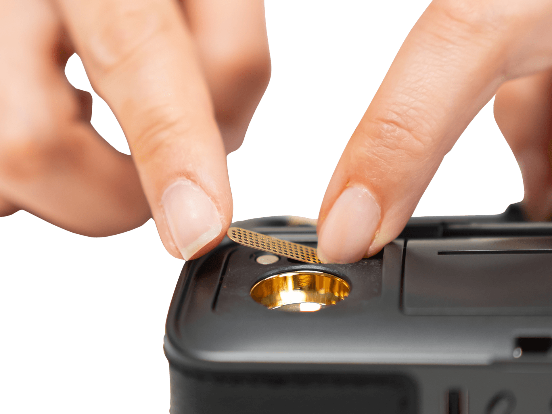 Fingers lifting removable magnetic screen off AirVape Legacy Pro 2 gold-plated oven