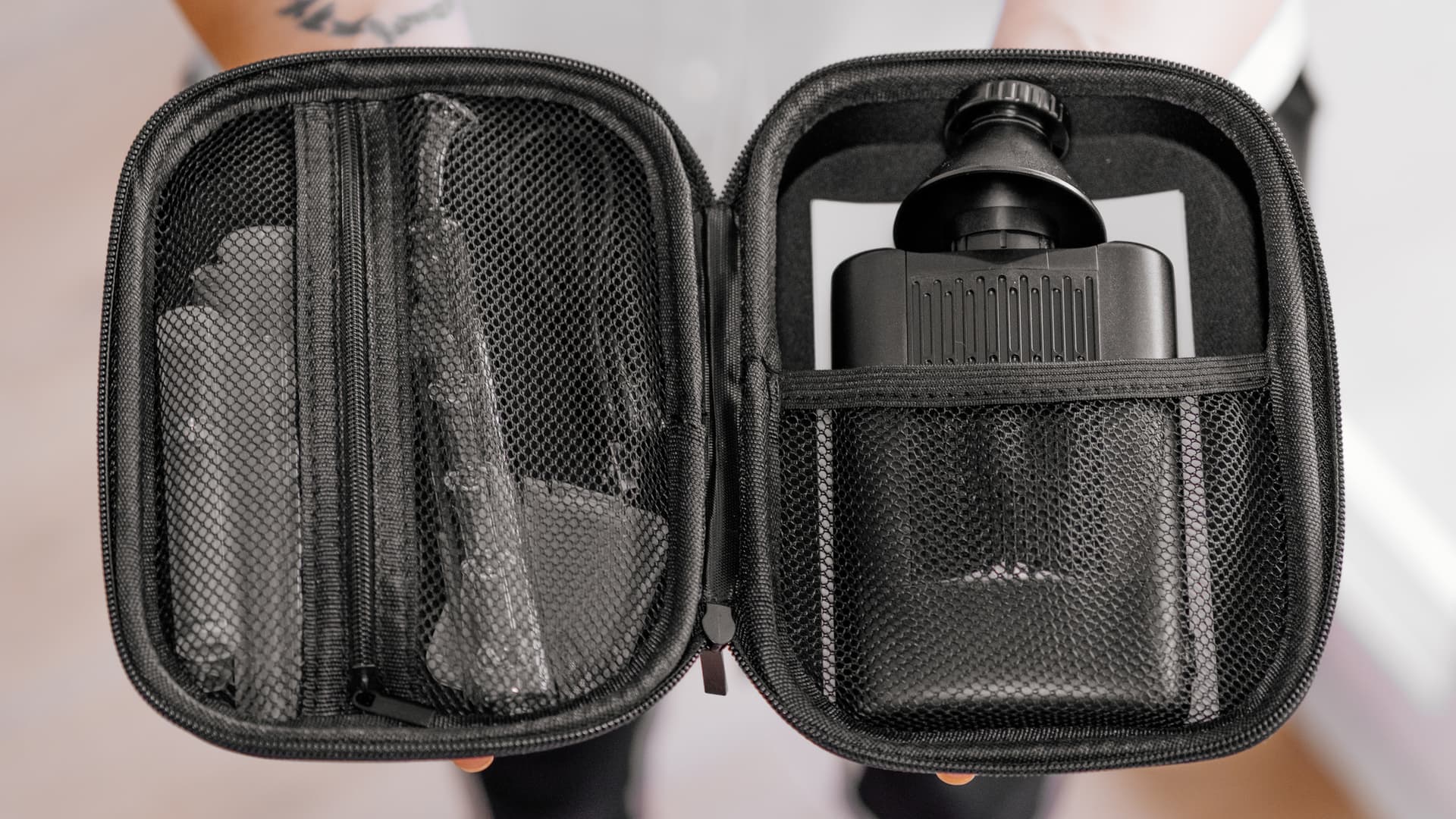 Angus Enhanced carrying case open showing netted compartments with the vaporizer and glass accessories