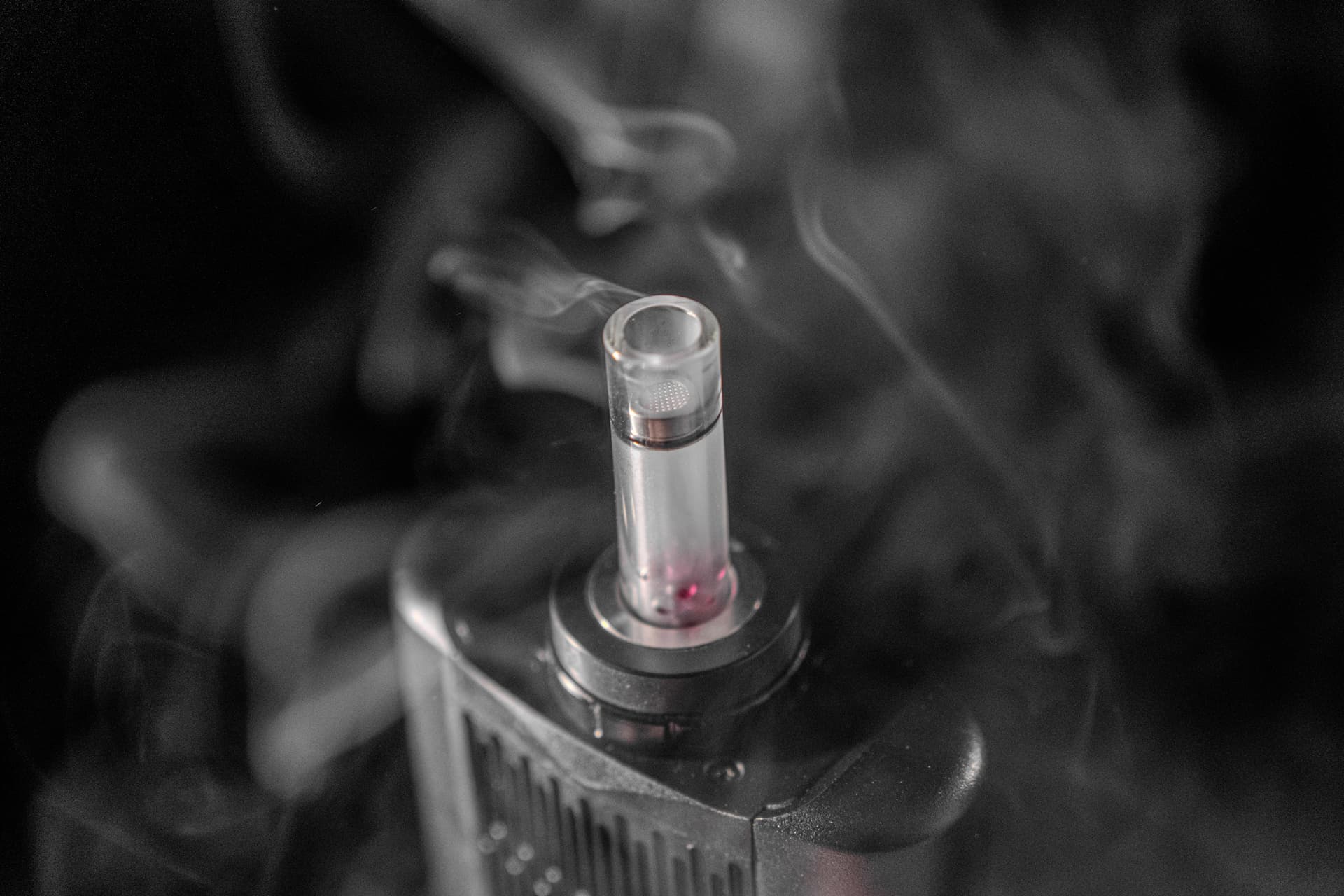 Angus Enhanced glass mouthpiece with ruby balls producing thick visible vapor in dramatic lighting