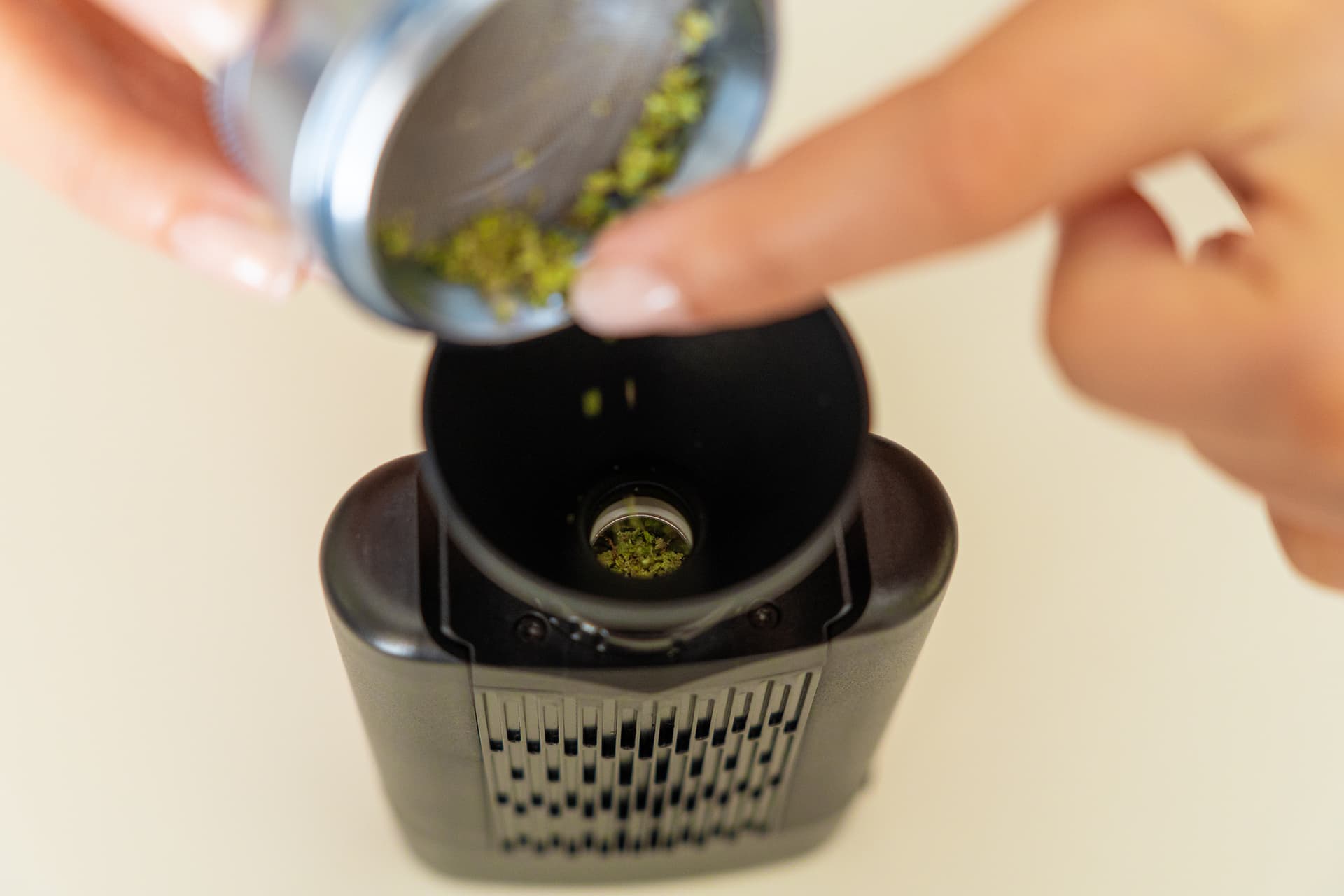 Loading dry herb into Angus Enhanced stainless steel oven through funnel accessory
