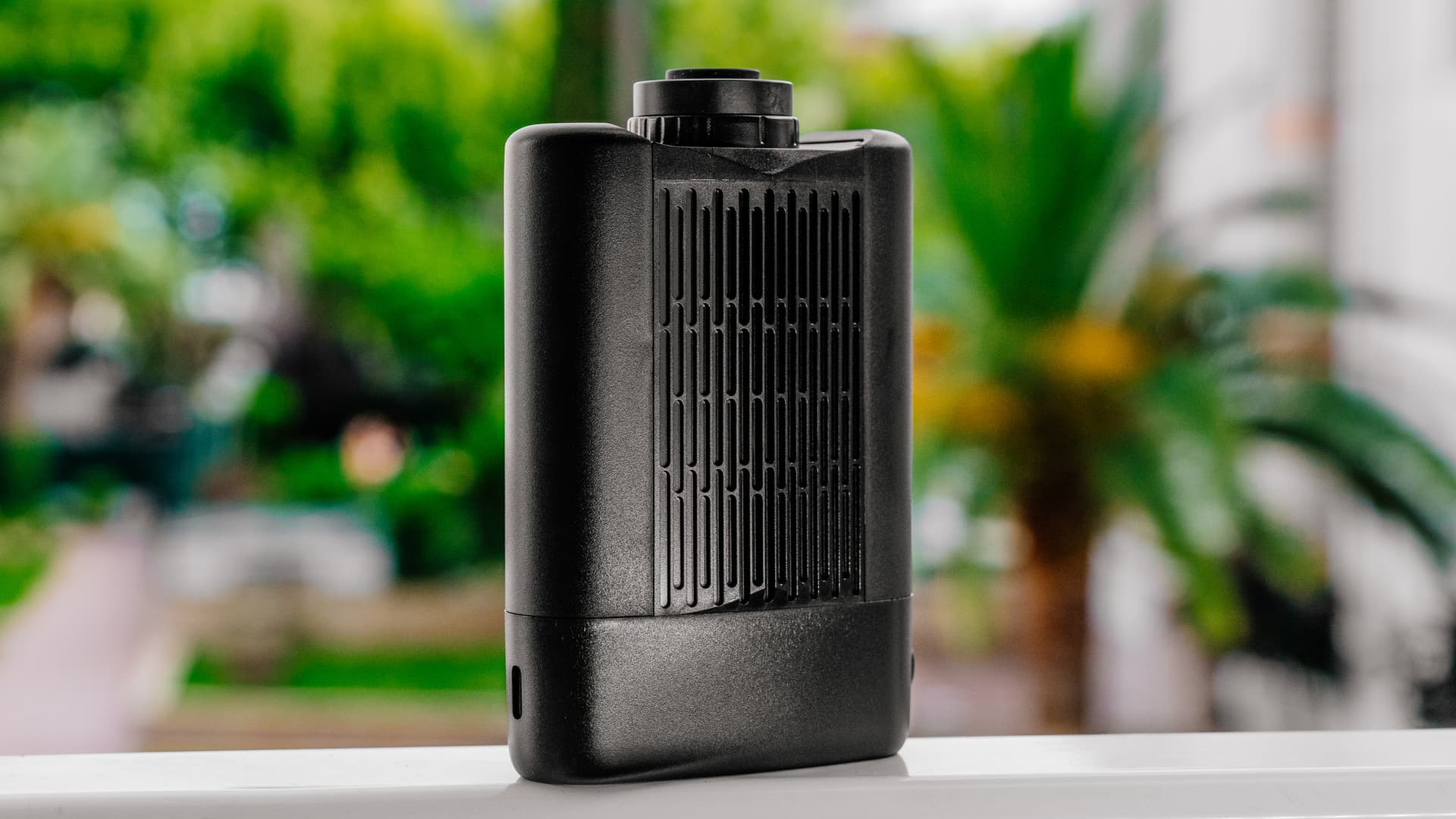 Angus Enhanced vaporizer standing outdoors with lush green background