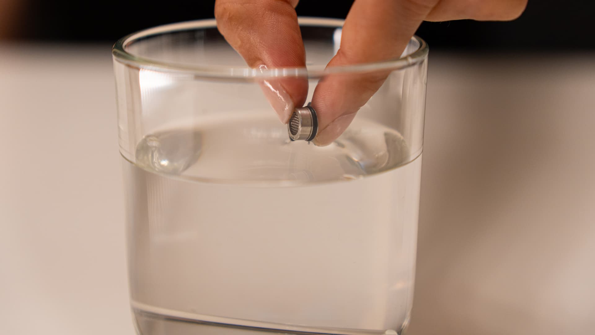 Ein kleines Filtersieb des Angus Enhanced wird in ein Glas mit Isopropylalkohol getaucht