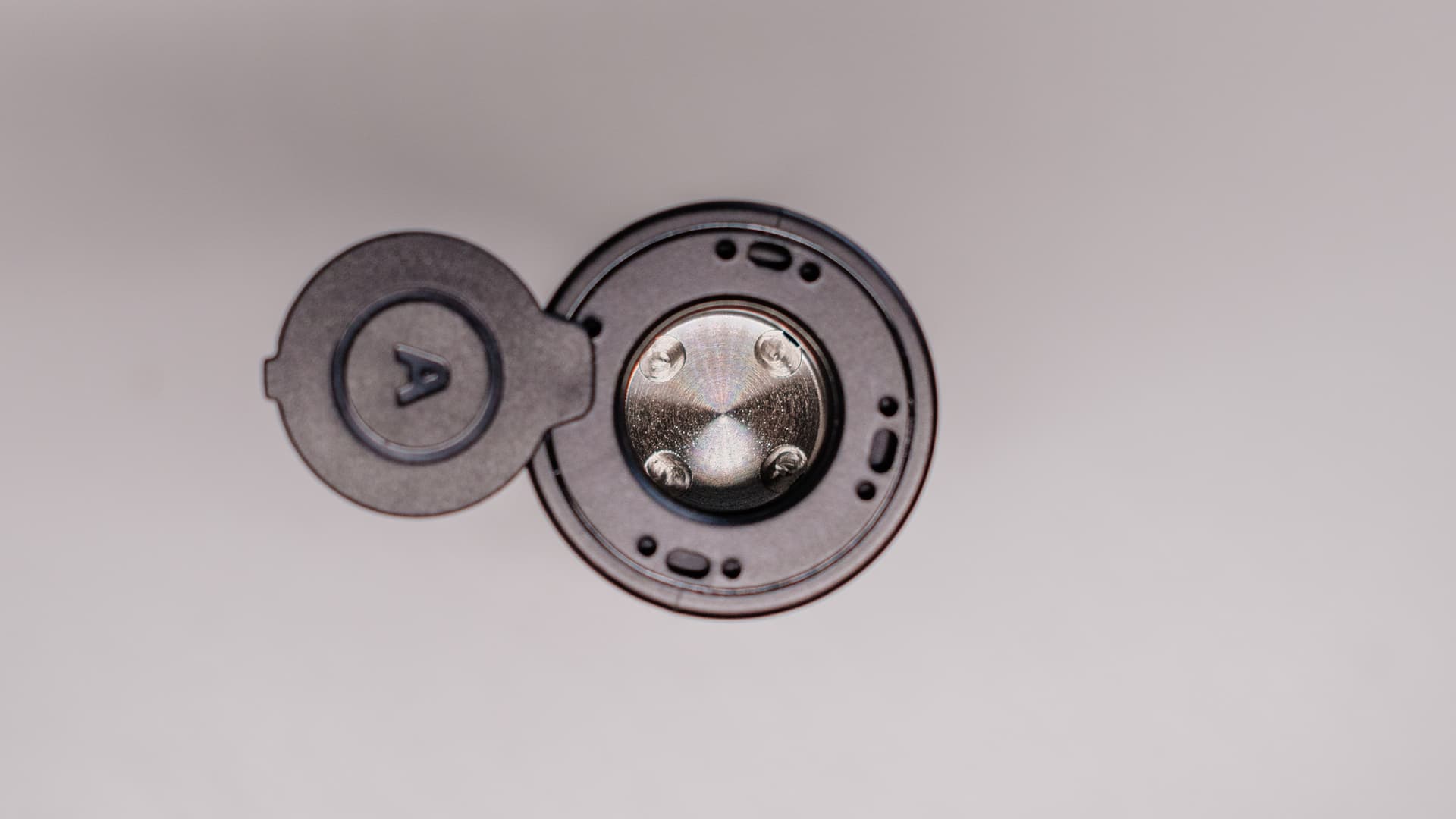 Arizer Air Max ceramic oven macro top-down with magnetic lid open showing glass-lined chamber and airflow holes