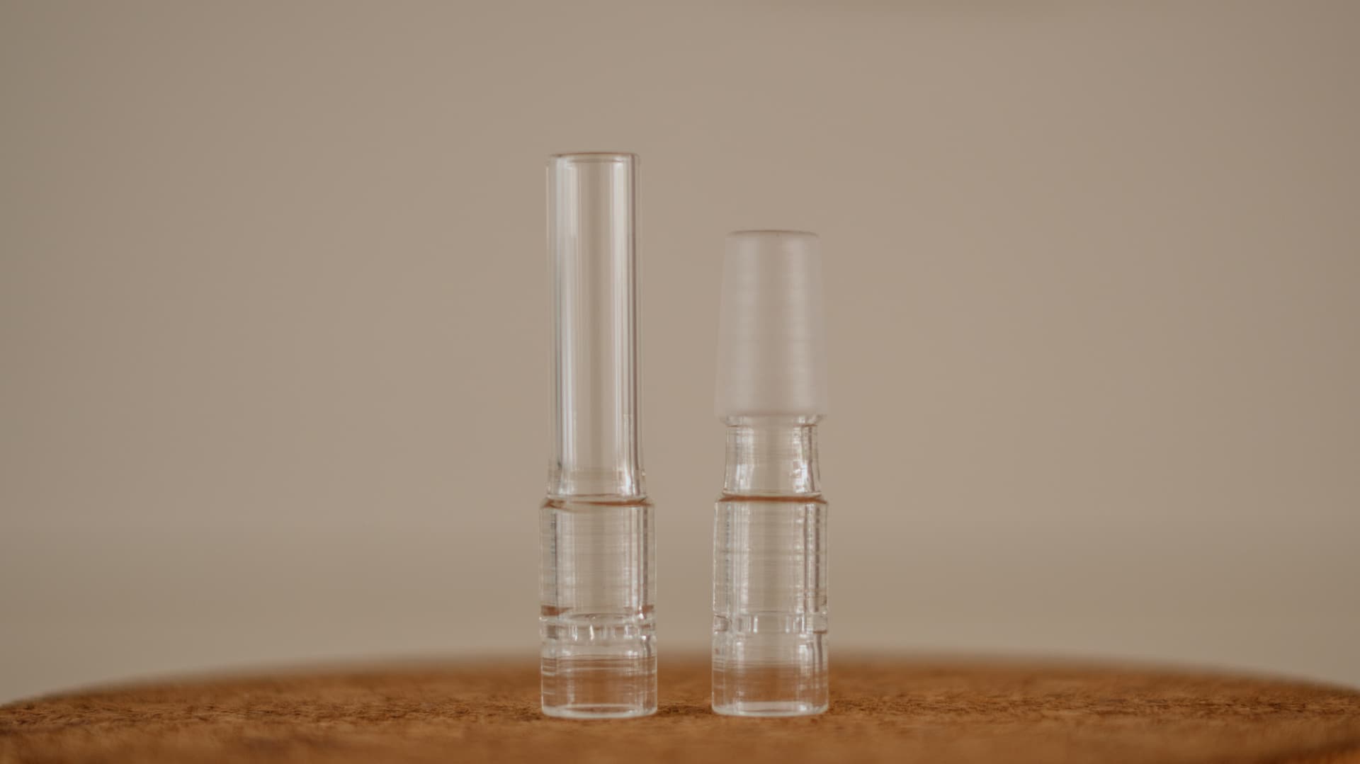 A row of clear borosilicate glass mouthpiece stems laid out on a clean light surface.