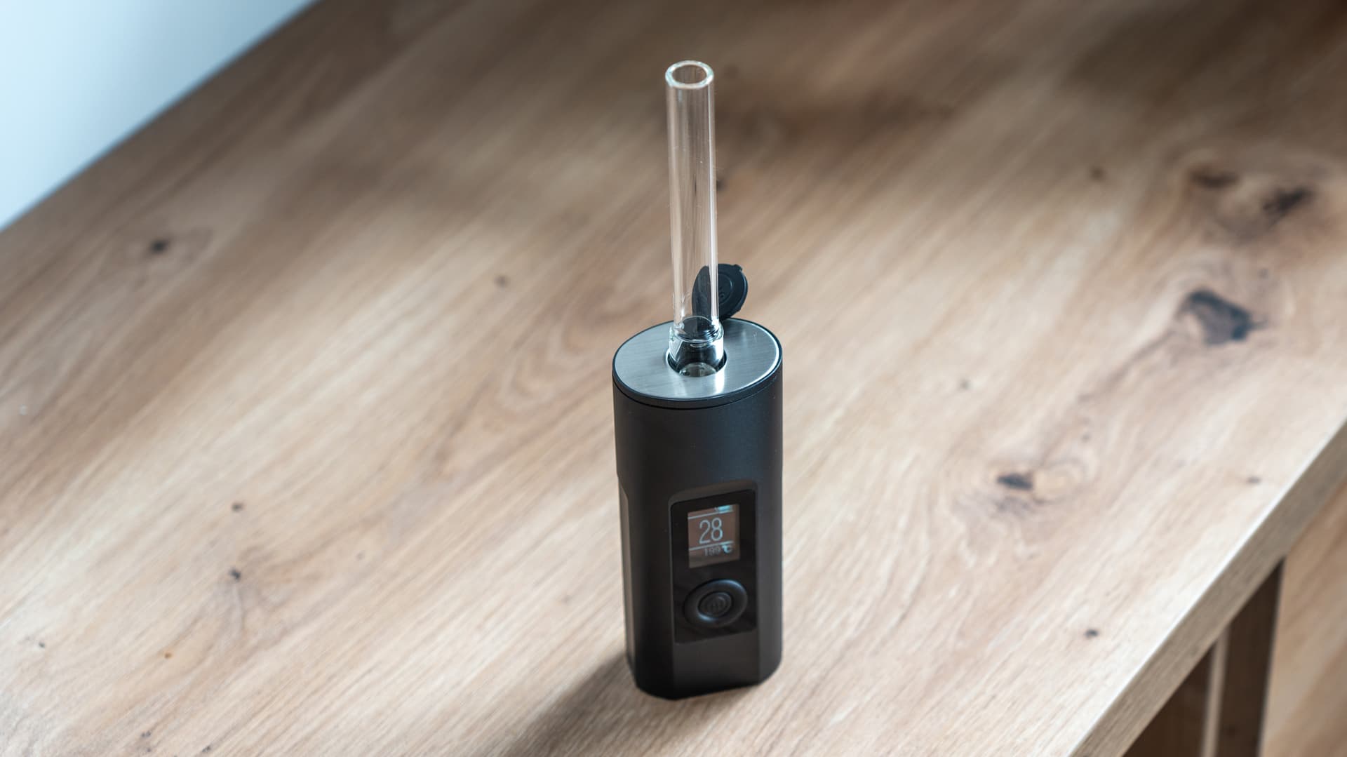 Arizer Solo 2 Max mit eingesetztem Glas-Stem aufrecht auf einem Holztisch