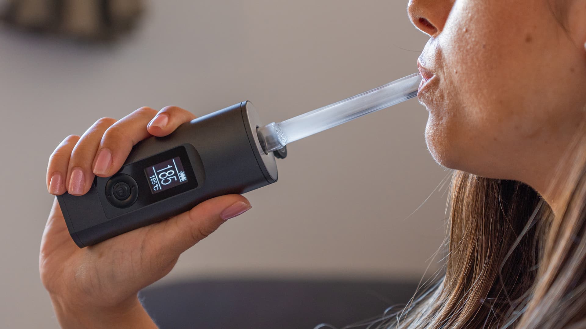 Person slowly inhaling from the Arizer Solo 2 Max through the glass stem