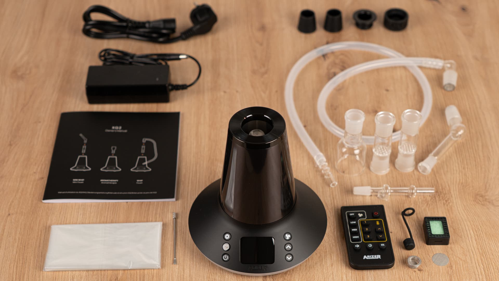 Complete Arizer XQ2 kit unboxed and laid out overhead with remote, glass parts, and balloon bags