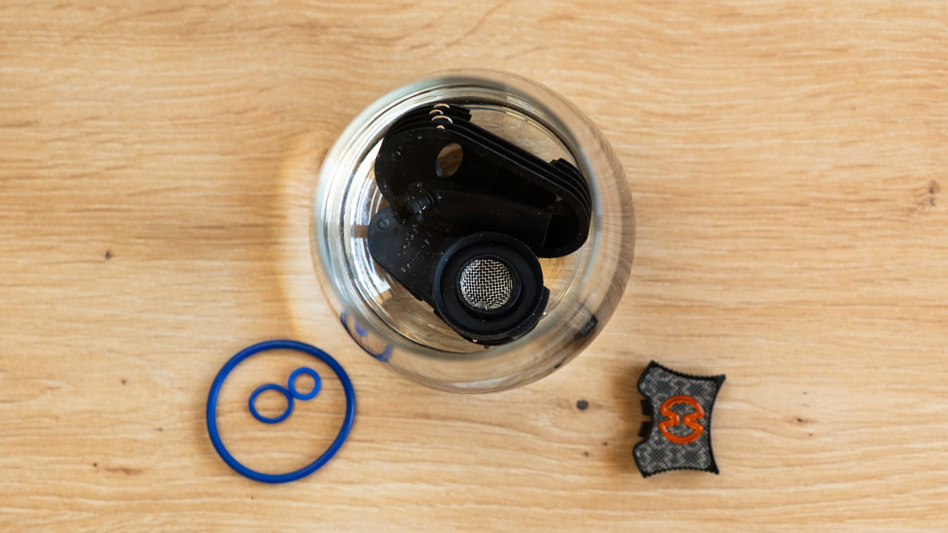 Cooling unit parts soaking in a glass, seal rings and cap lock set aside