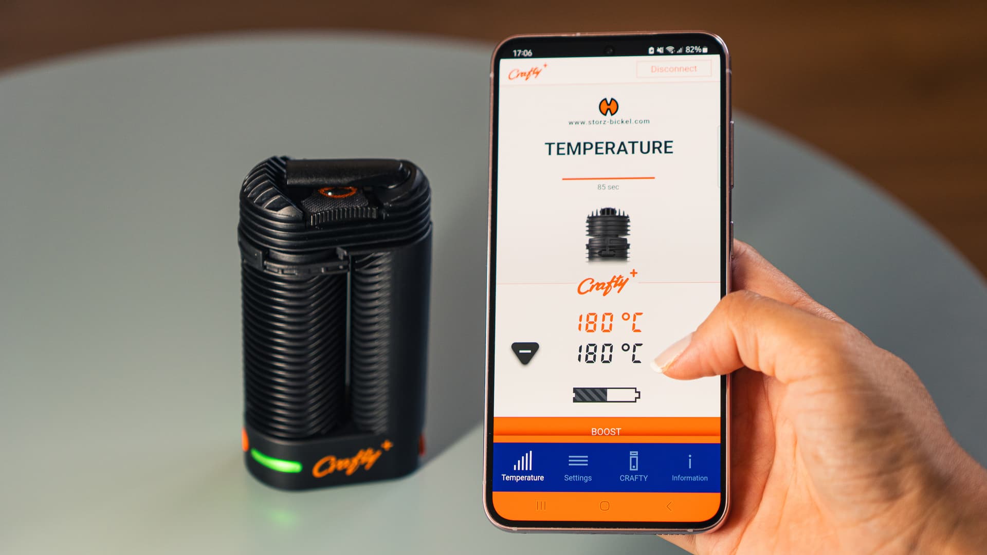 Smartphone zeigt die Temperaturansicht der Storz & Bickel-App neben dem Crafty+ mit grüner Bereitschafts-LED