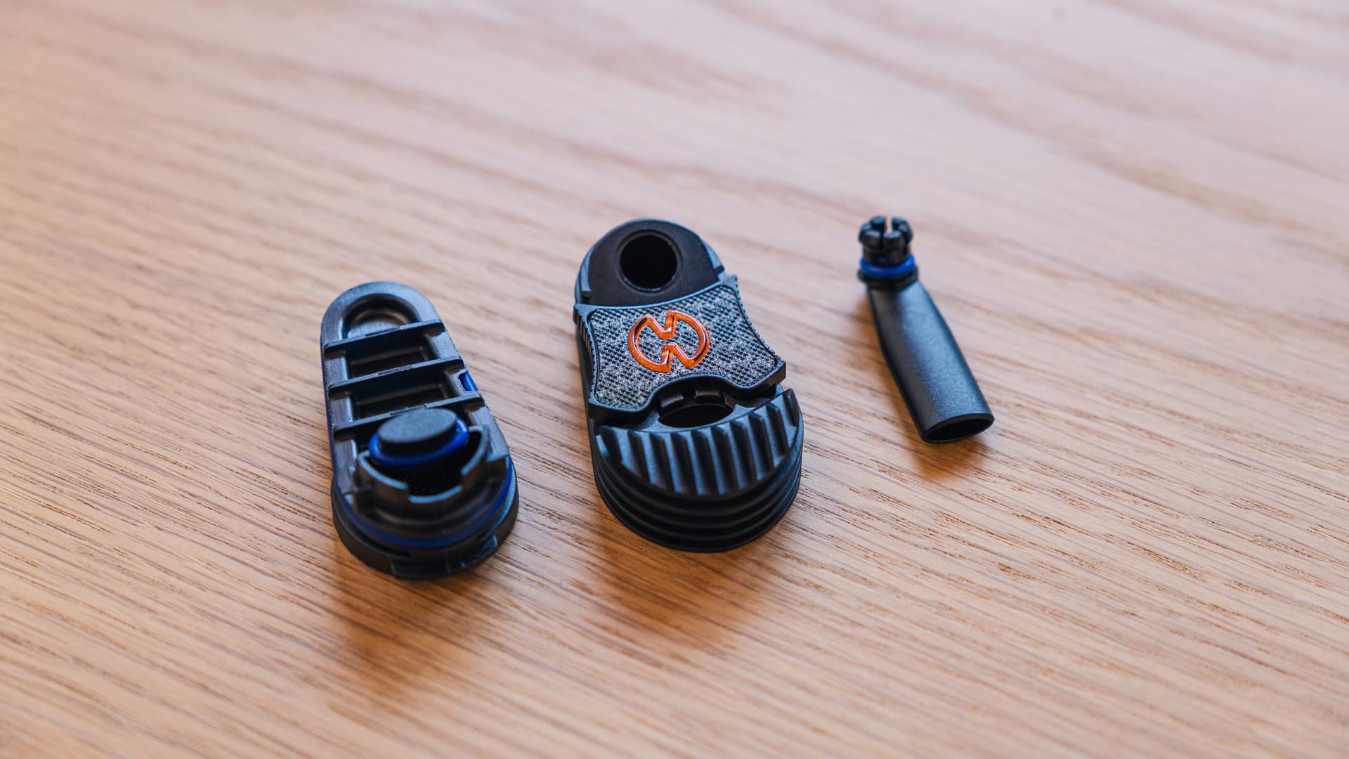 A Storz & Bickel cooling unit fully disassembled into its component parts on a wood surface