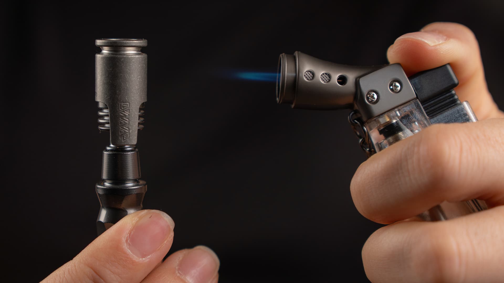 DynaVap cap being heated by a butane torch flame, blue flame meeting the metal tip