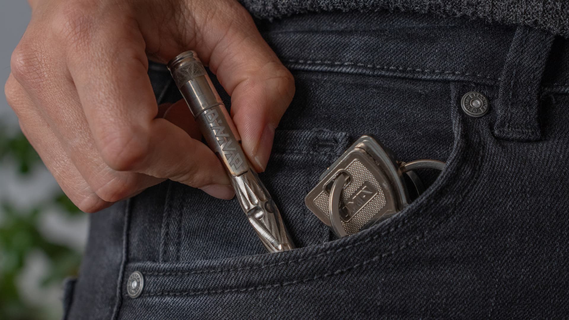 DynaVap UniDyn aus der Münztasche einer Jeans gezogen, neben Schlüsseln, zeigt, wie ultrakompakt und tragbar er ist