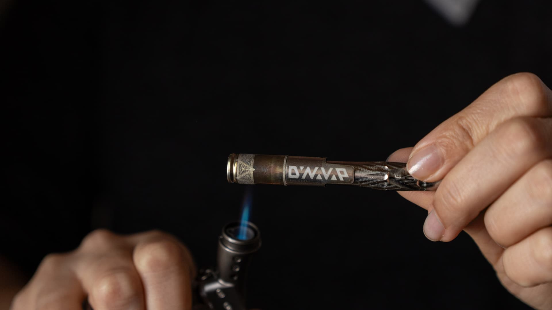 DynaVap UniDyn wird mit einem Sturmfeuerzeug erhitzt, Flamme an der oberen Kappe, zeigt die richtige Rotationstechnik