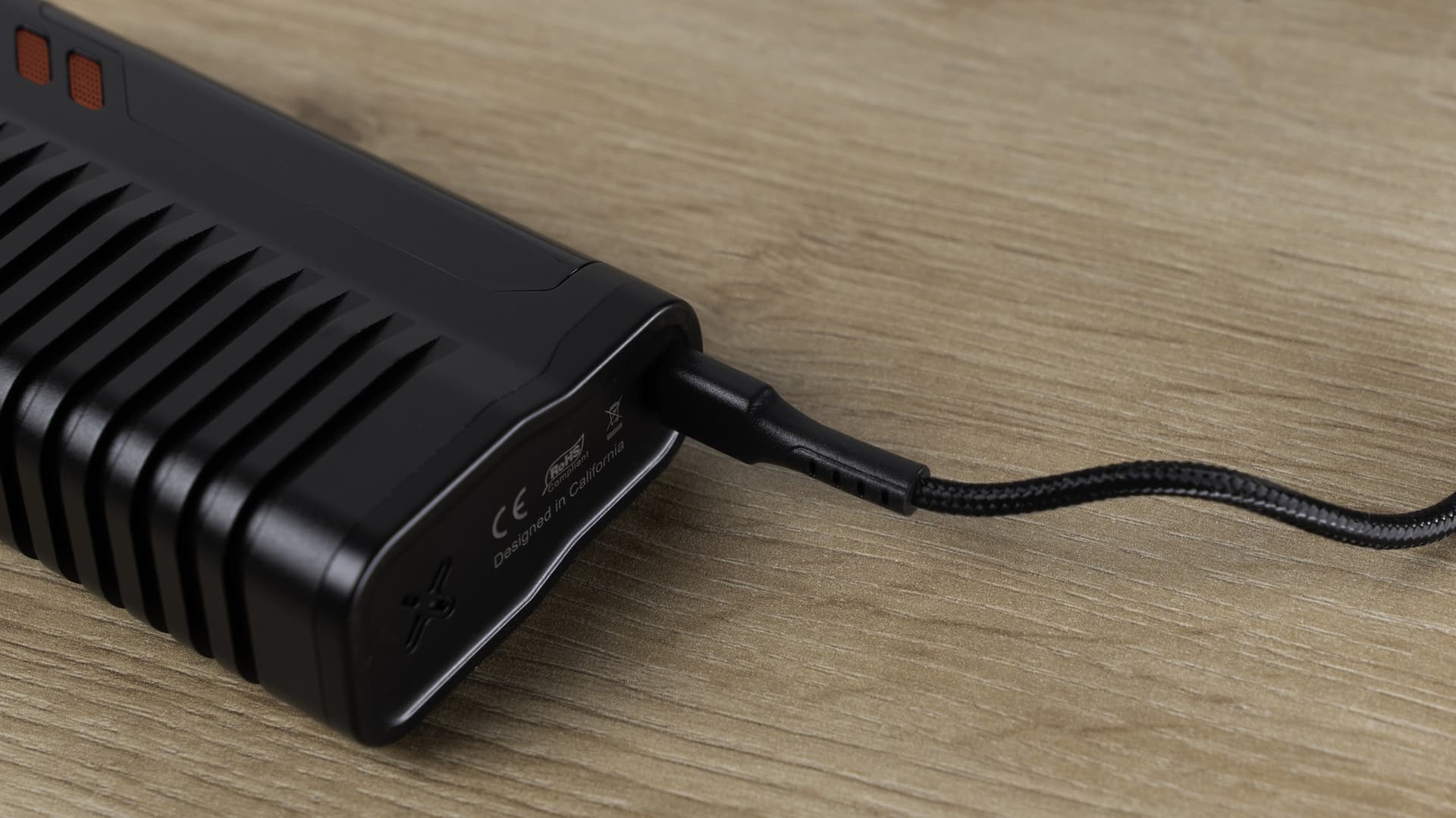 Fenix 2 MAX base with USB-C charging cable connected and regulatory markings visible on a wooden surface