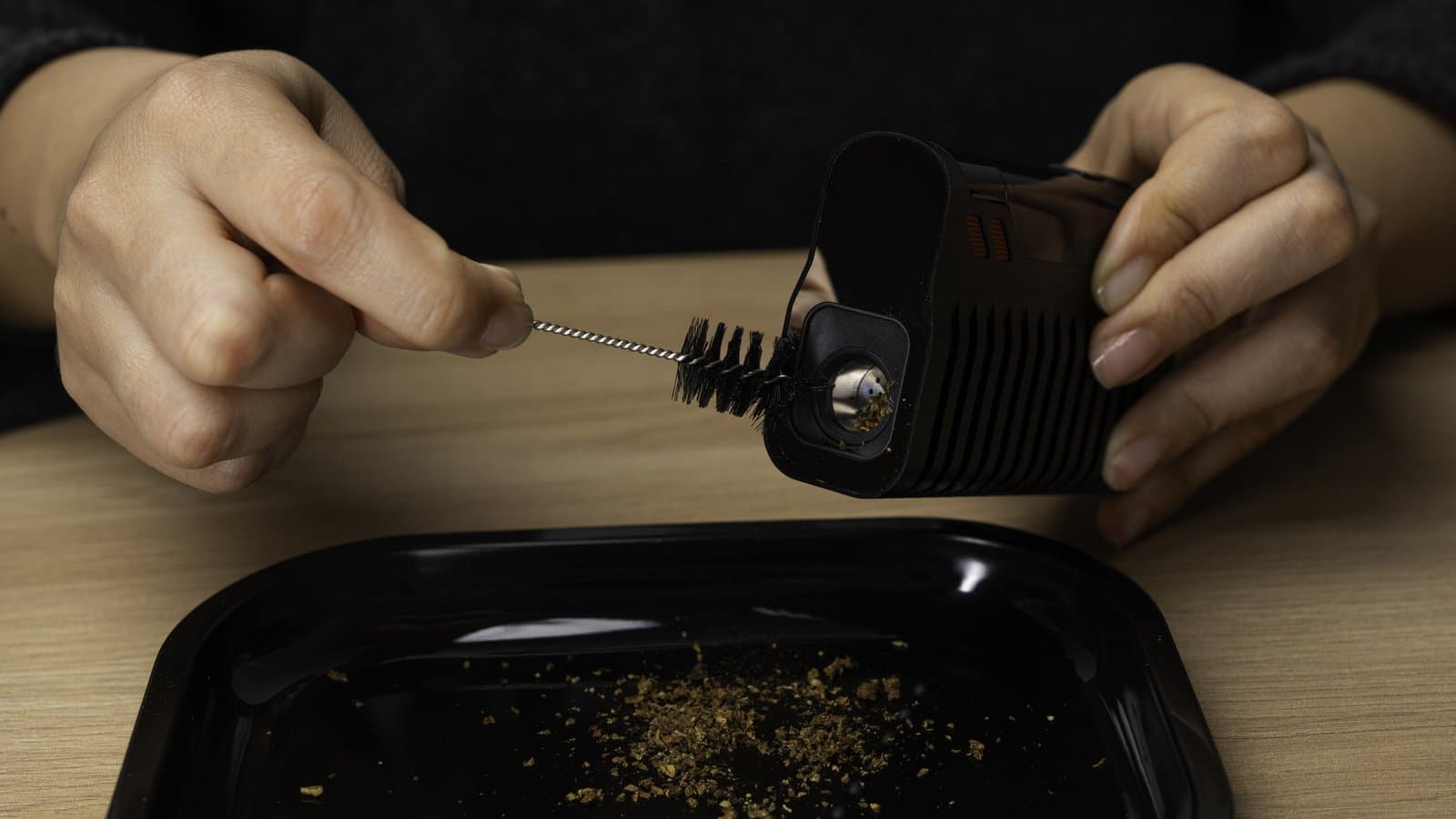 Verbrauchtes Cannabis über einer Schale aus der Kammer des Fenix 2 MAX bürsten