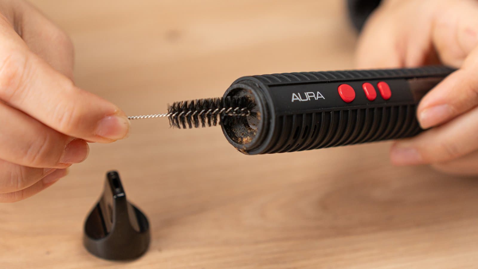 Reinigung der Heizkammer des Flowermate Aura mit Bürste, Mundstück abgenommen auf dem Tisch