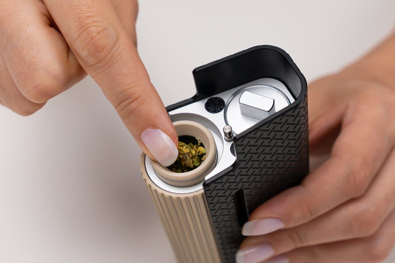 Settling ground cannabis into the open Frolic oven with a fingertip