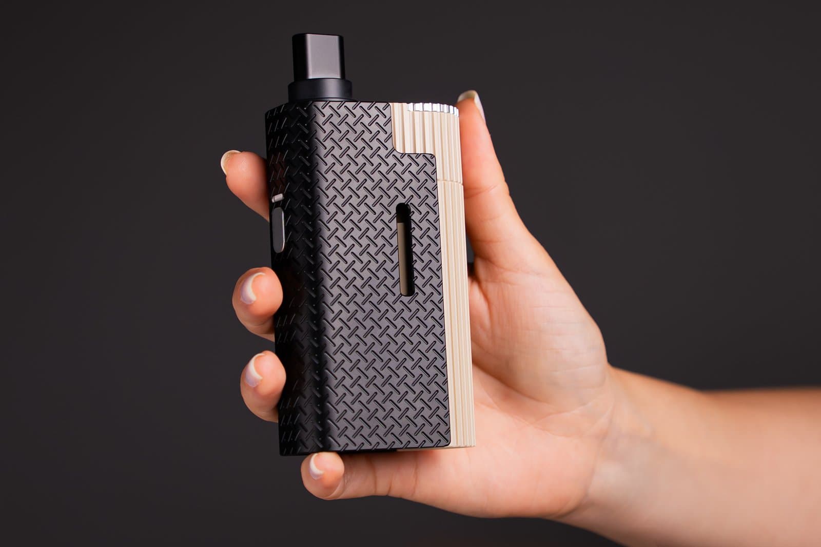 Hand hält den Limelight Frolic, der Daumen liegt nahe der seitlichen Power-Taste; zeigt, wie der 245 g schwere Vaporizer bei normalem Griff in der Hand liegt