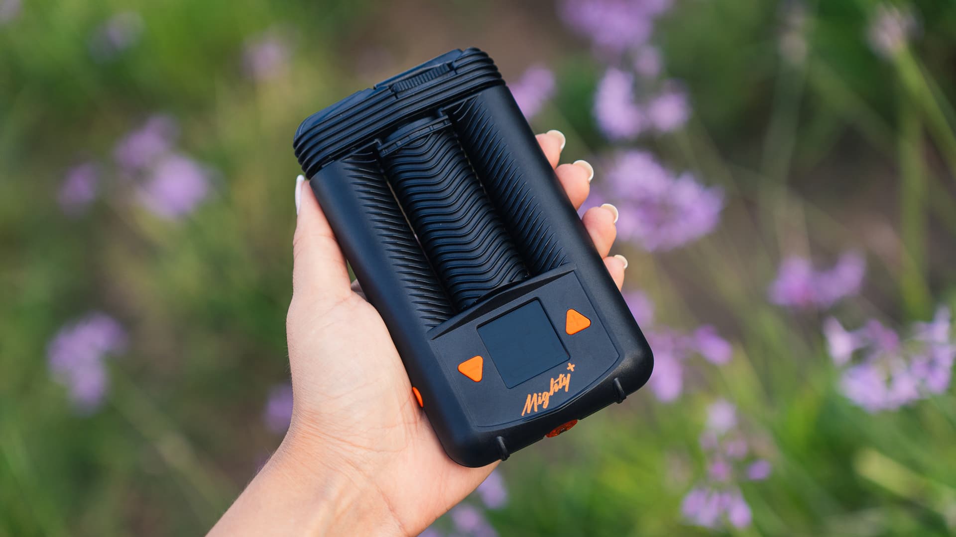 A Mighty+ vaporizer photographed on a warm wood surface, showing its sealed lithium-polymer battery design