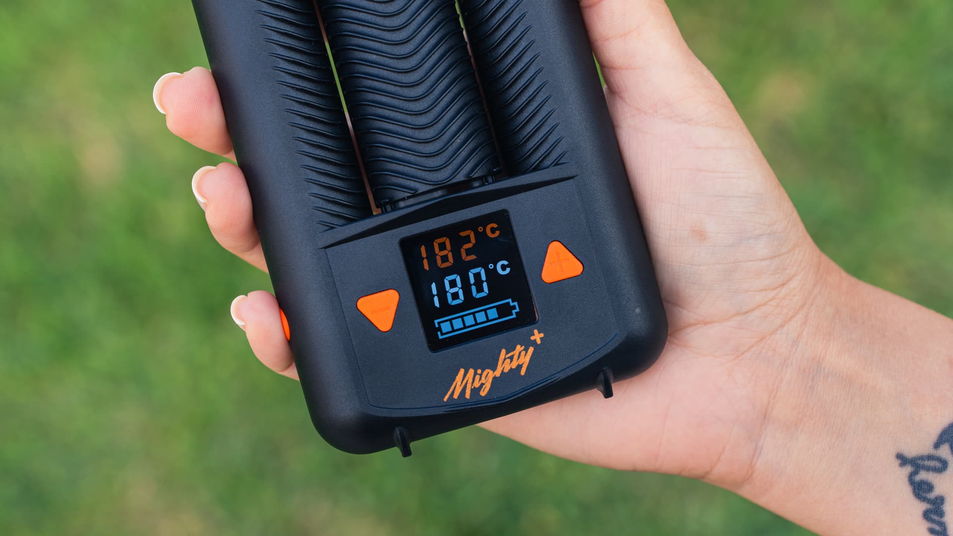 Mighty+ held in hand, display showing the set temperature