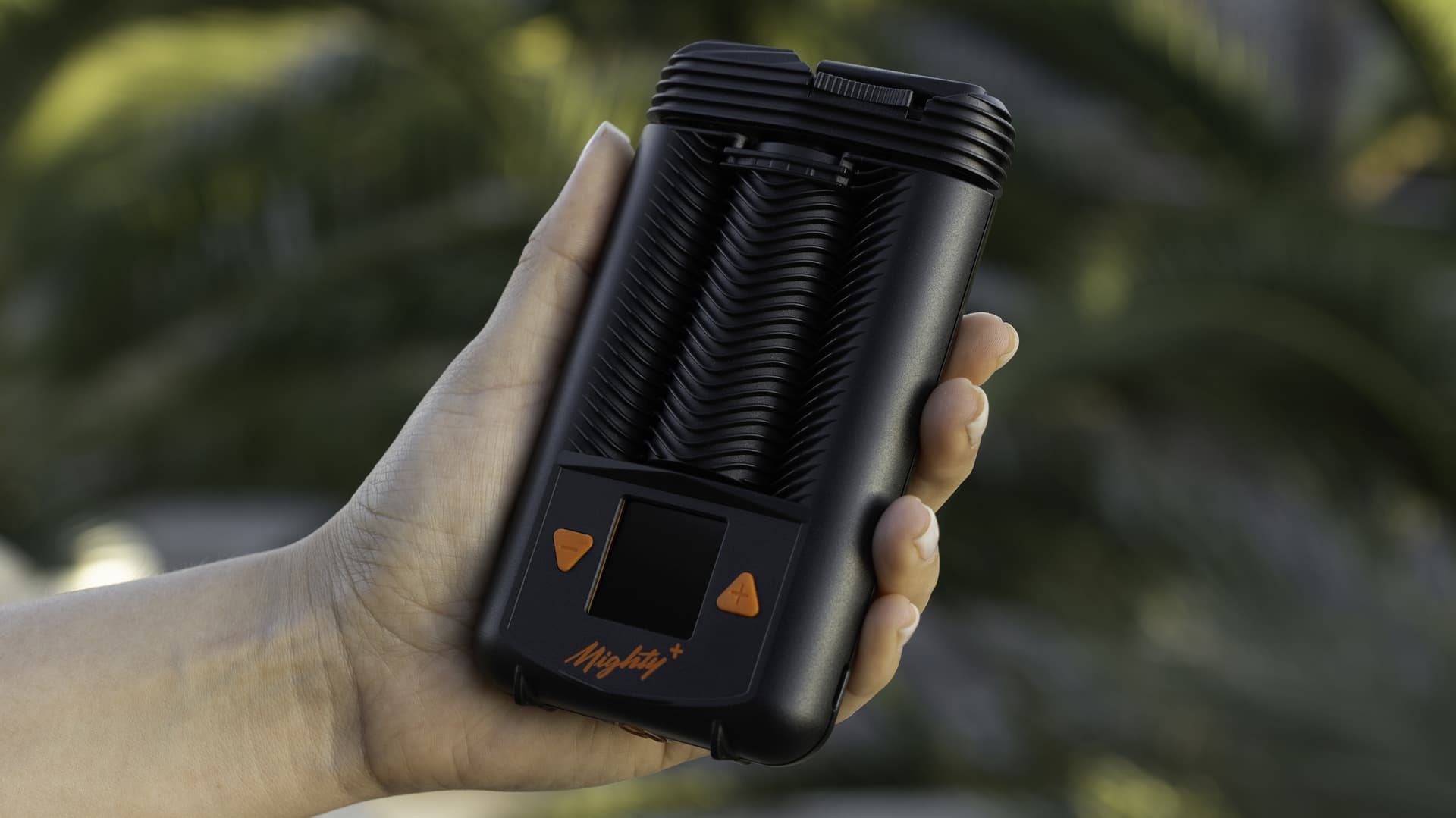 A Mighty+ held in hand with the chevron-patterned stainless steel cooling unit detached and visible