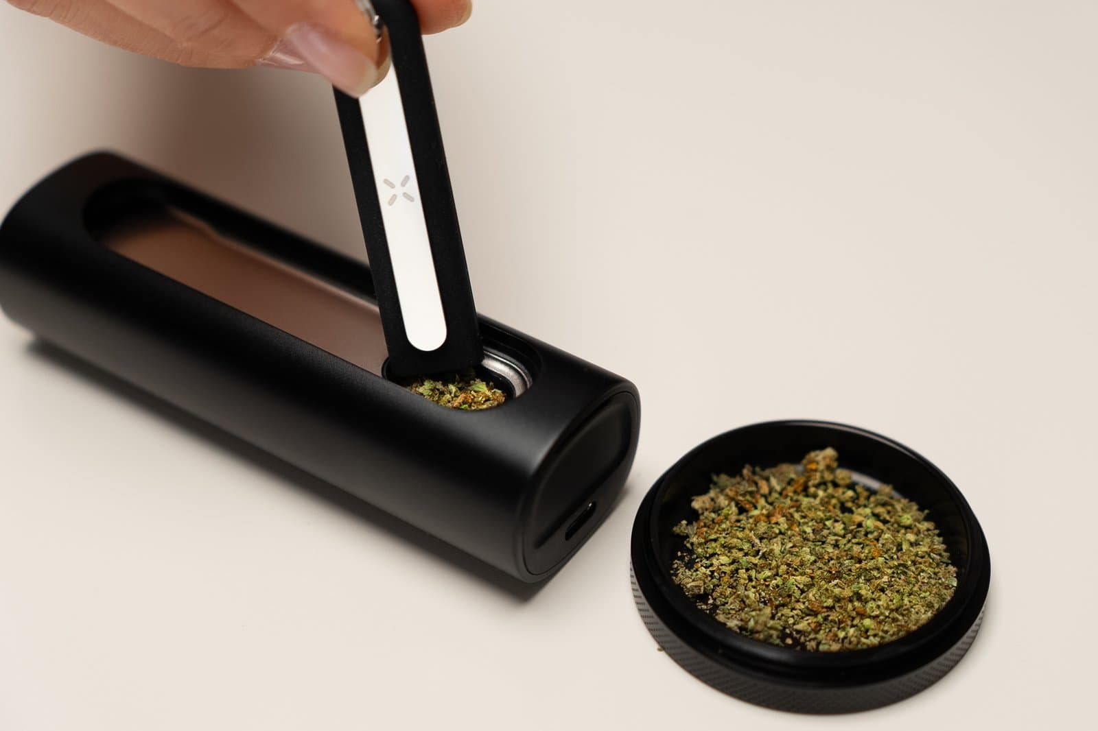 Multi-Tool drückt gemahlenes Cannabis in die seitliche Heizkammer des PAX Flow fest