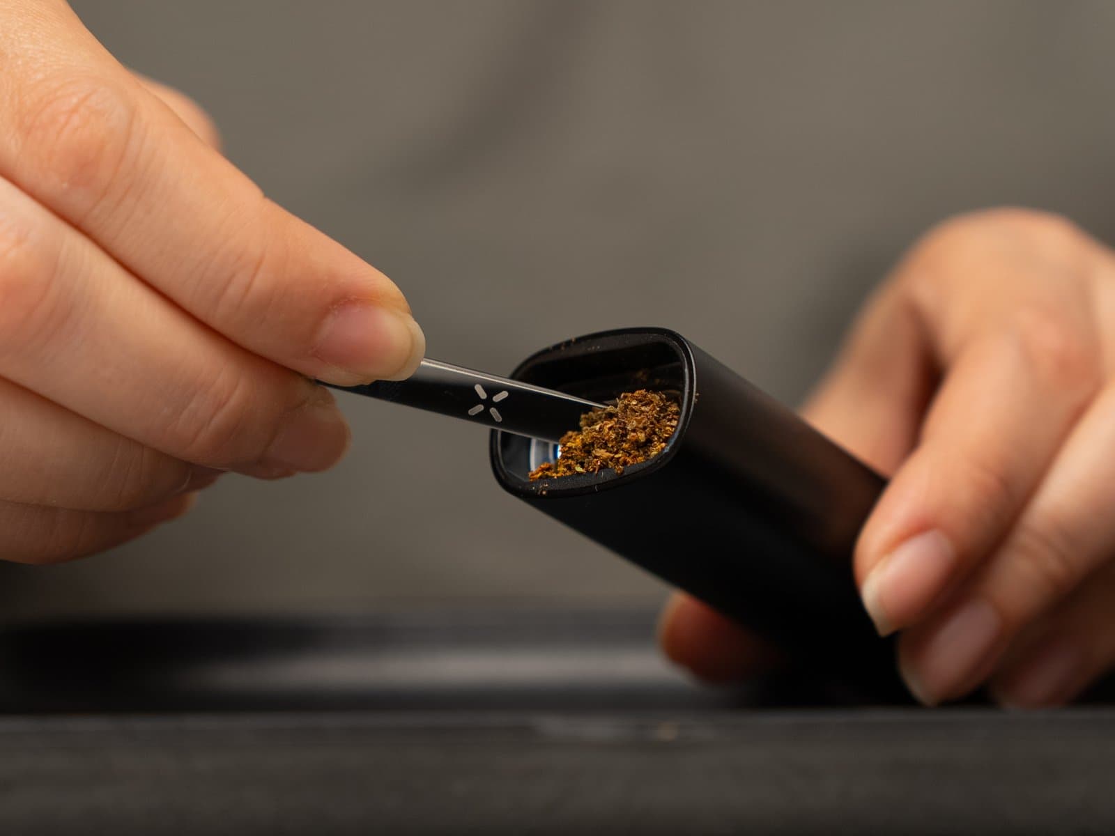 Packing ground cannabis into the PAX Mini 2 oven with the multi-tool