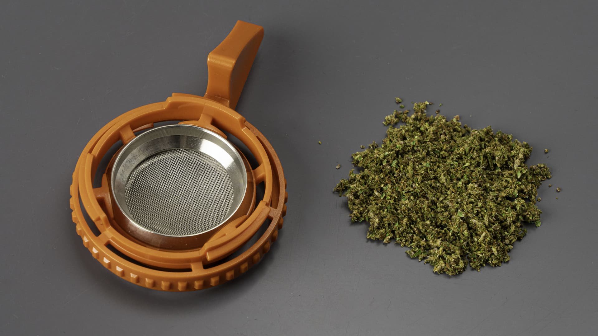 Plenty vaporizer filling chamber with screen next to ground dry herb showing ideal consistency