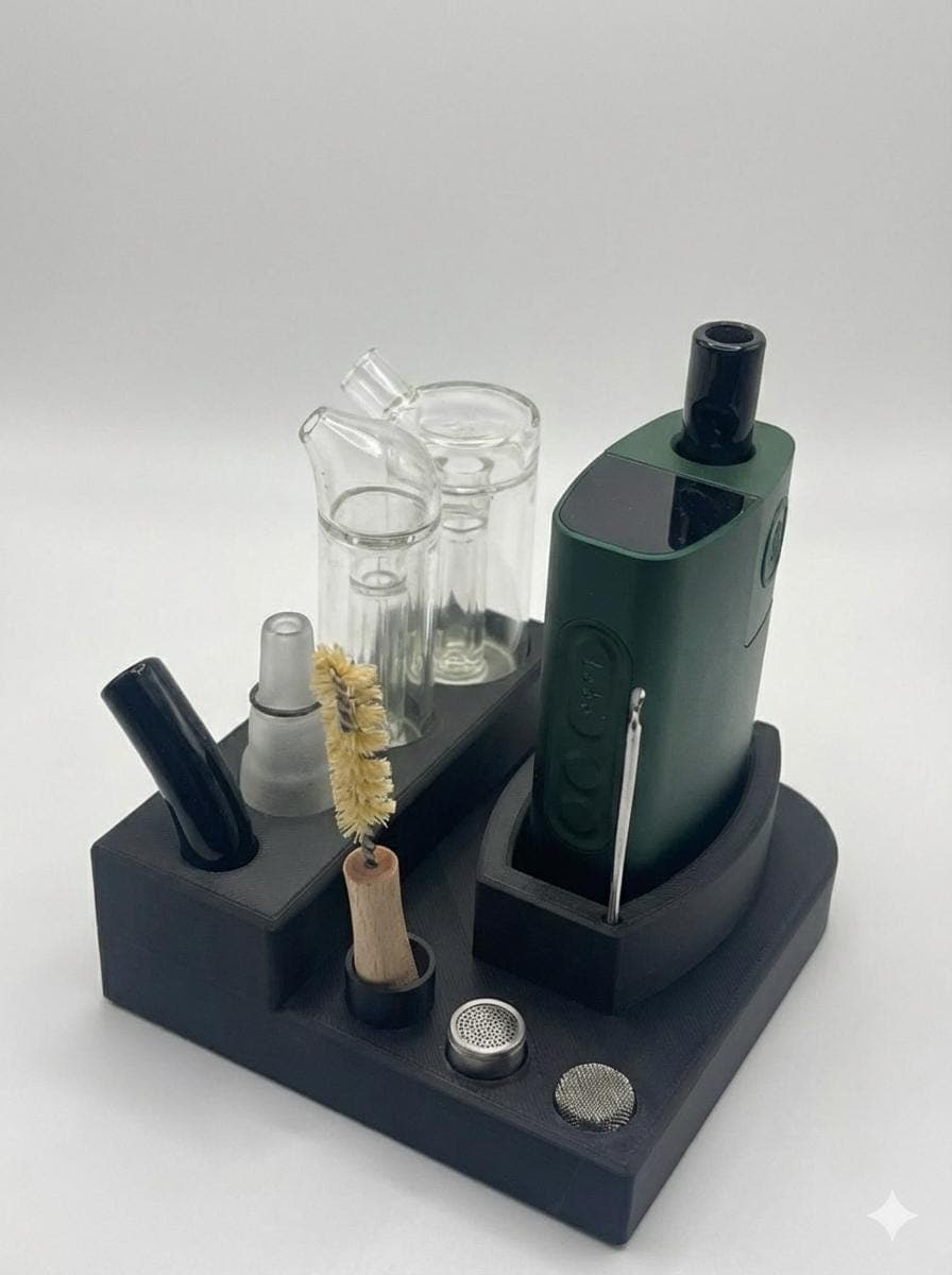 Green POTV Lobo on a stand surrounded by the full included kit: glass stems, cleaning brush, spare screens, dosing capsule, and loading tool