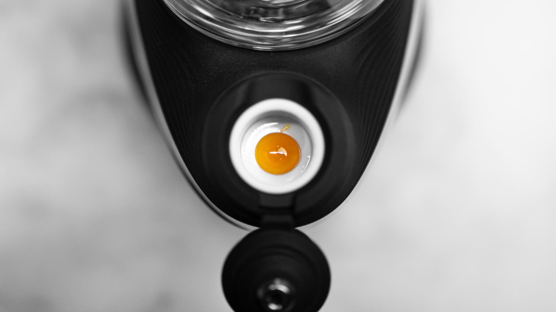 Draufsicht auf bernsteinfarbenes Konzentrat in der weißen Keramikschale des Puffco New Peak, Joystick-Cap angehoben