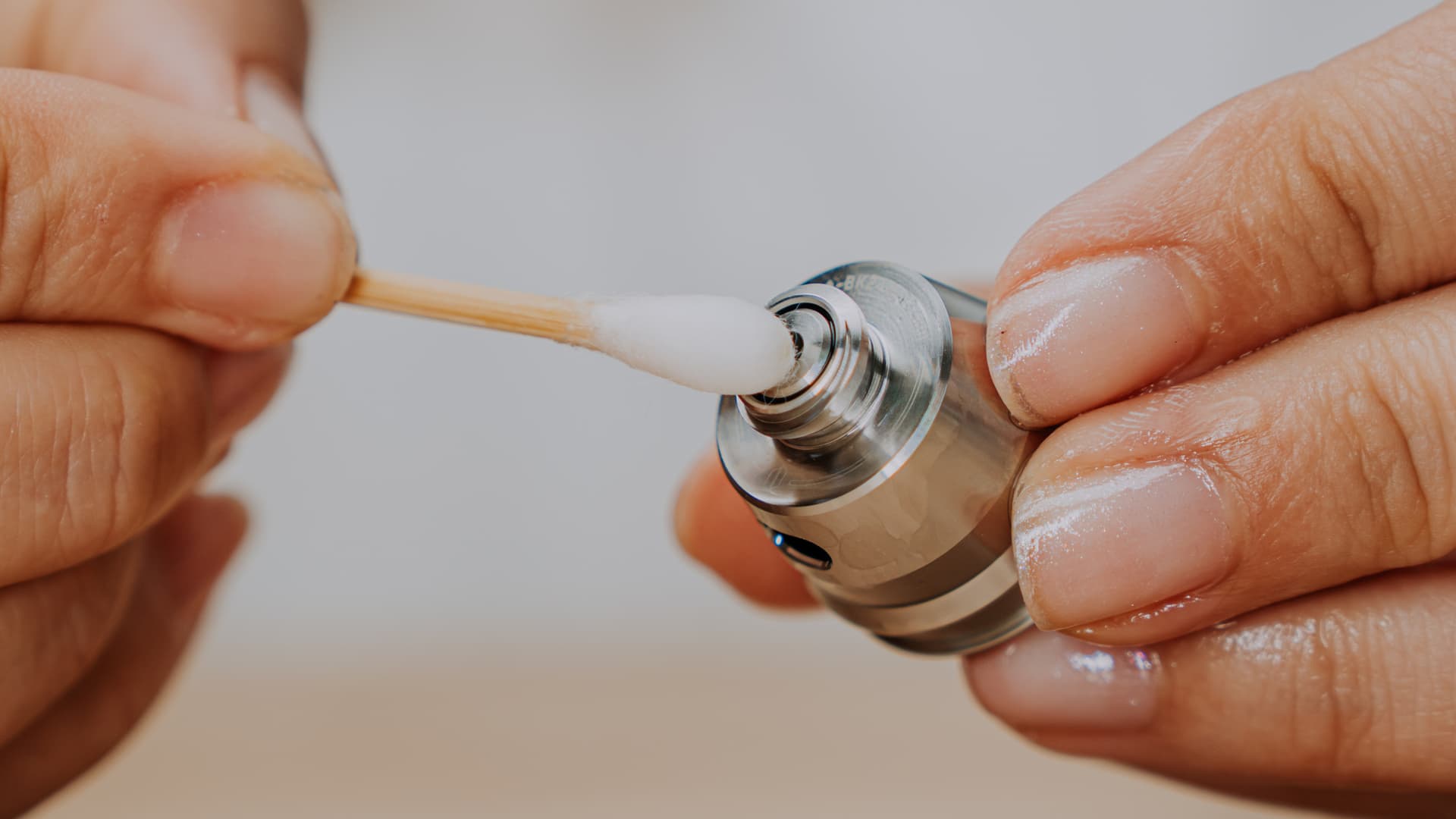 Cotton swab cleaning a detached Puffco New Peak chamber
