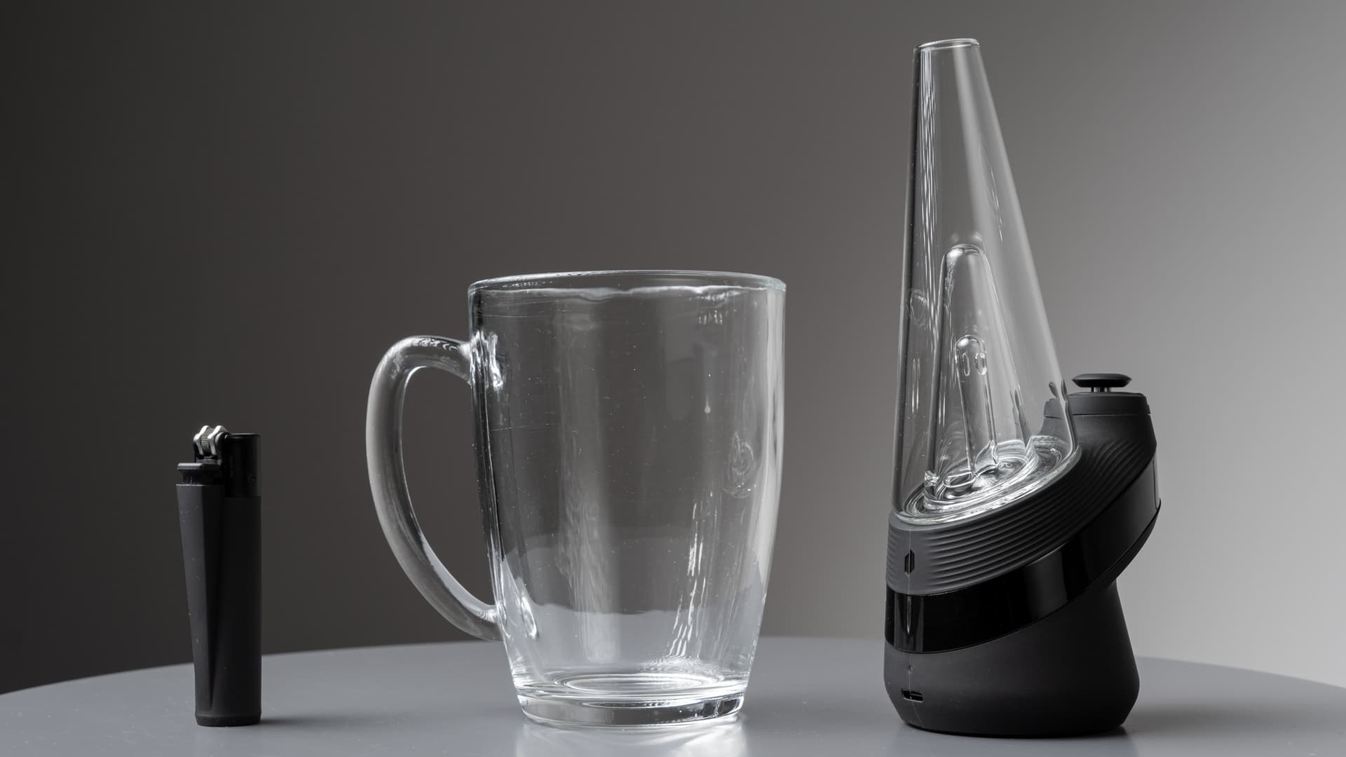 Größenvergleich des Puffco New Peak neben einer Kaffeetasse und einem Feuerzeug