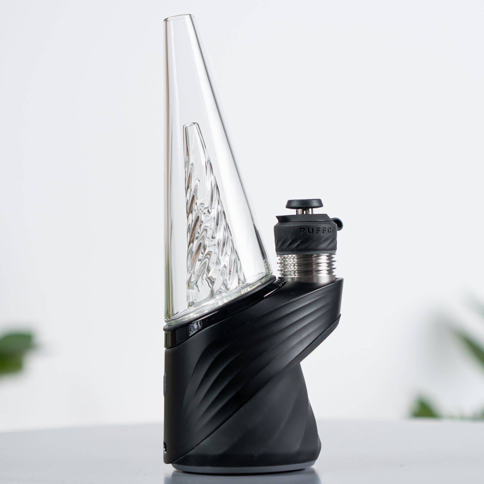 Schwarzer Puffco Peak Pro mit klarem Glas-Bubbler, Seitenansicht auf Weiß