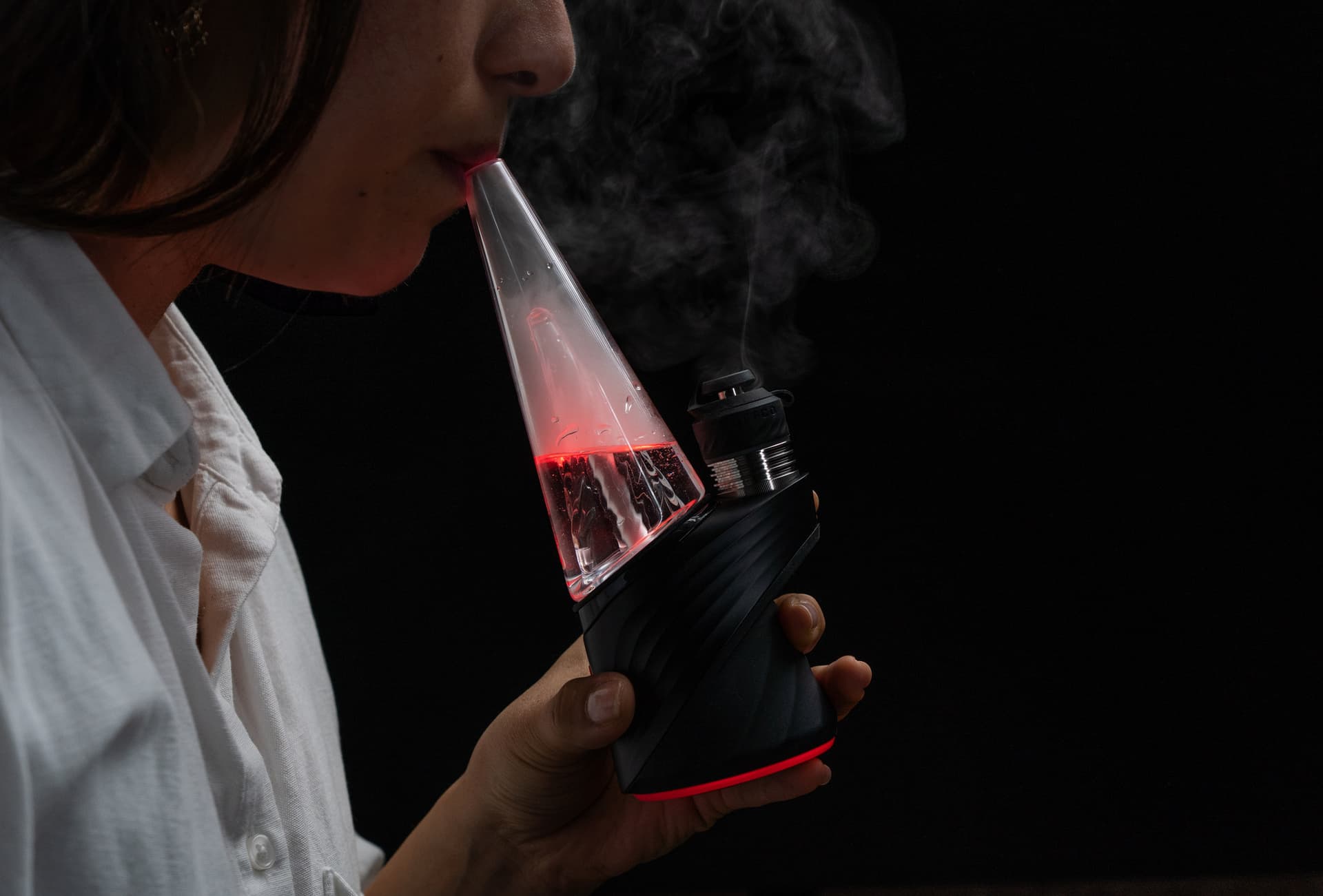 Puffco Peak Pro 3DXL eRig in active use with visible vapor rising from the glass bubbler and the LED ring glowing