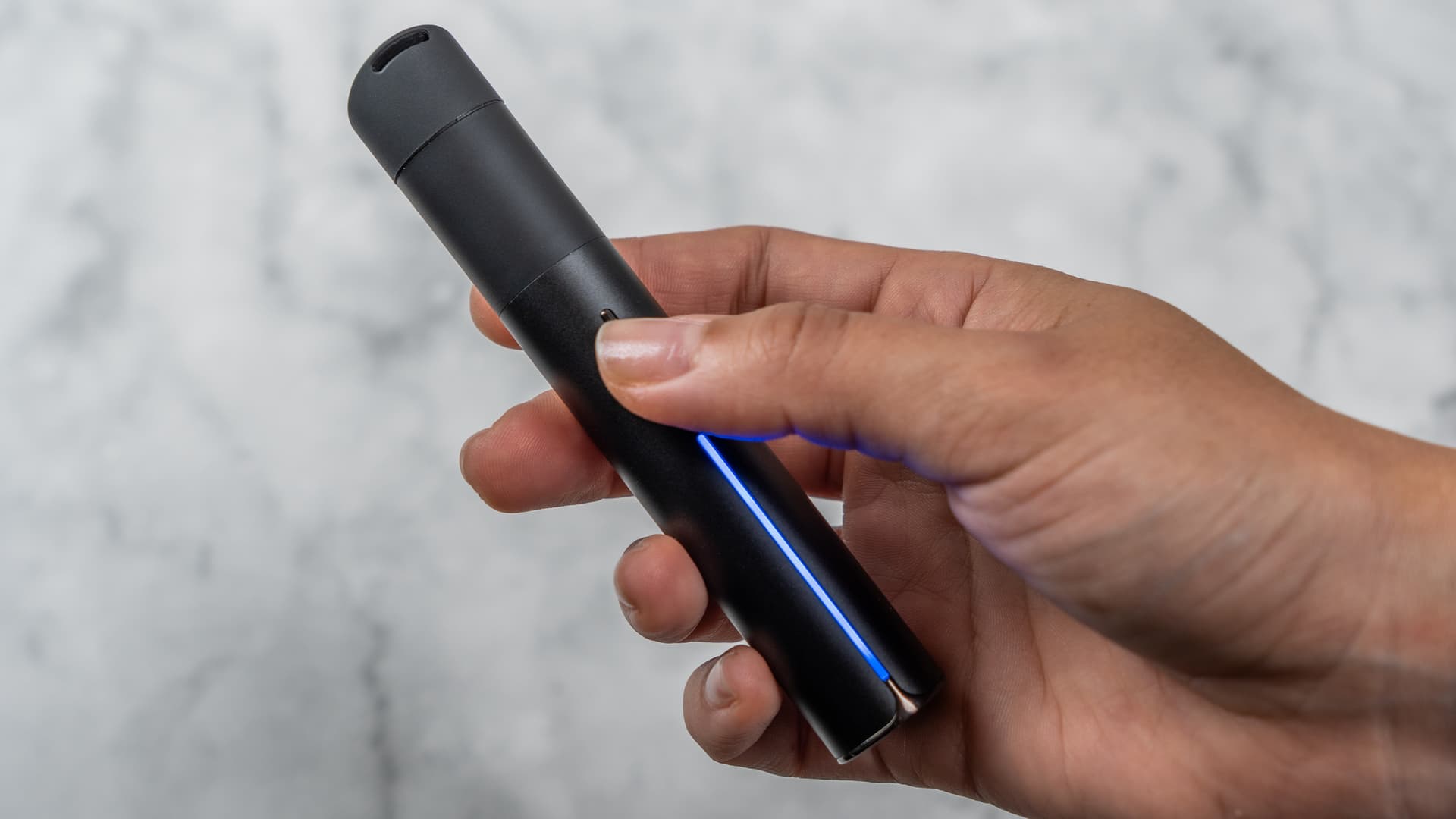 Puffco Pivot held in a hand, showing the compact pen-sized form factor