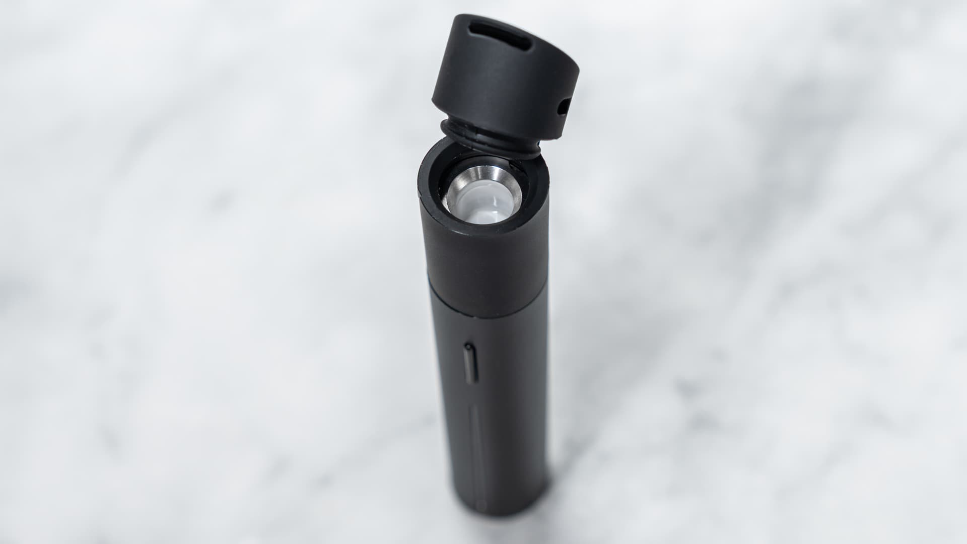 Puffco Pivot auf Marmoroberfläche mit aufgeklapptem Mundstück und freiliegender 3D-Keramikkammer