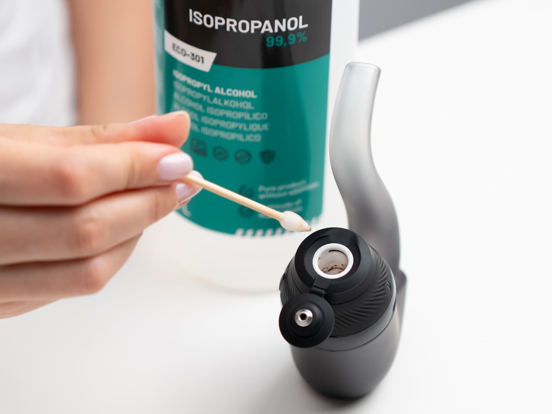 Hand reinigt die Puffco Proxy 3D-Keramikkammer mit einem in Isopropylalkohol getränkten Wattestäbchen