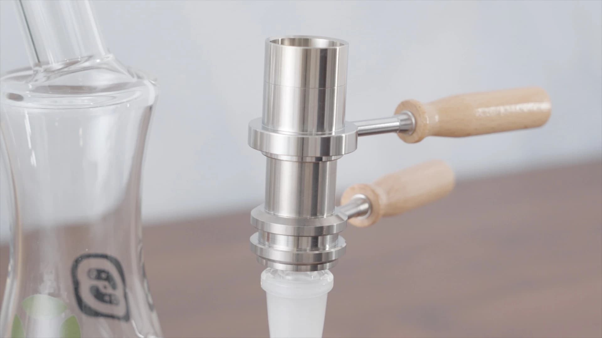 Ruby Twist Pro wand with wooden handle seated on glass bubbler showing heating element connection