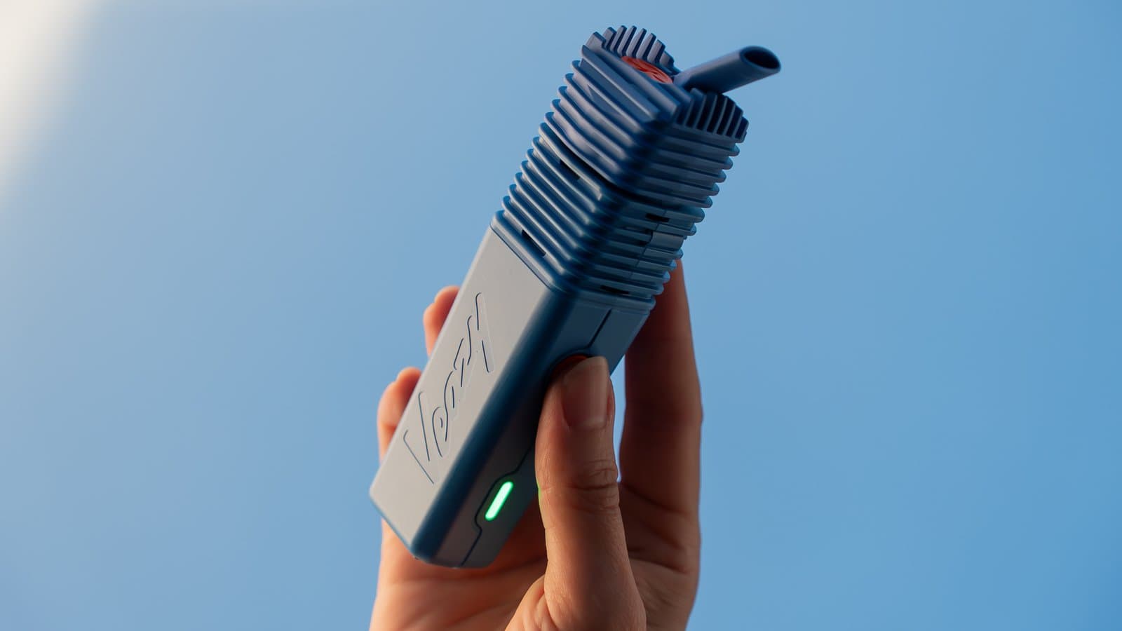 Hand hebt blauen Veazy mit grüner LED vor klarem Himmel