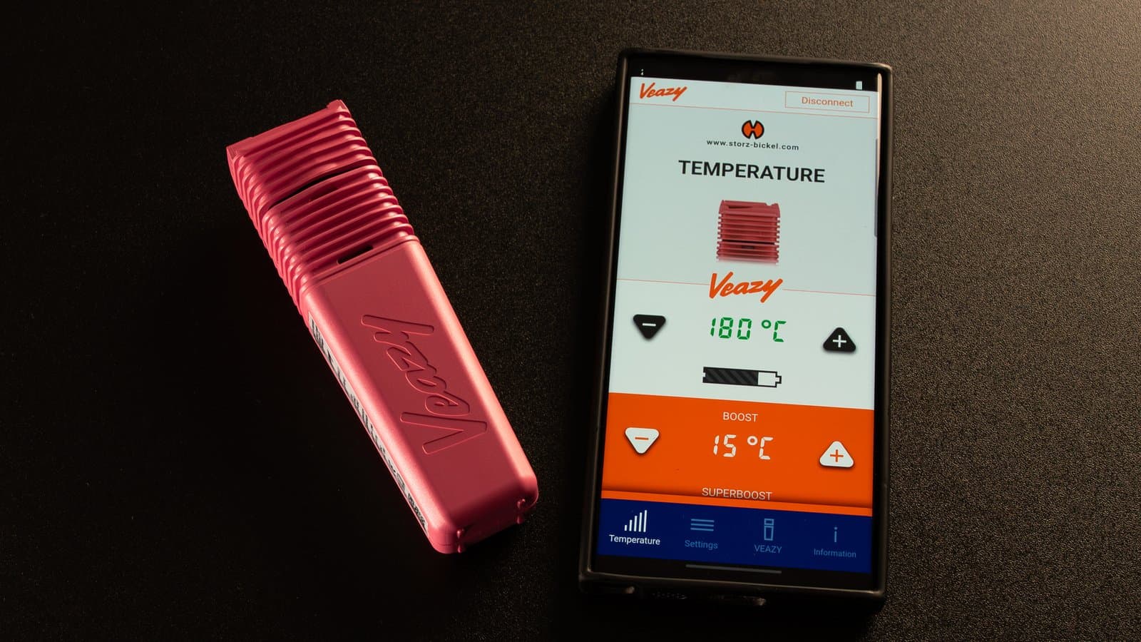 Pinker Veazy neben Smartphone mit Web-App bei 180°C und Boost