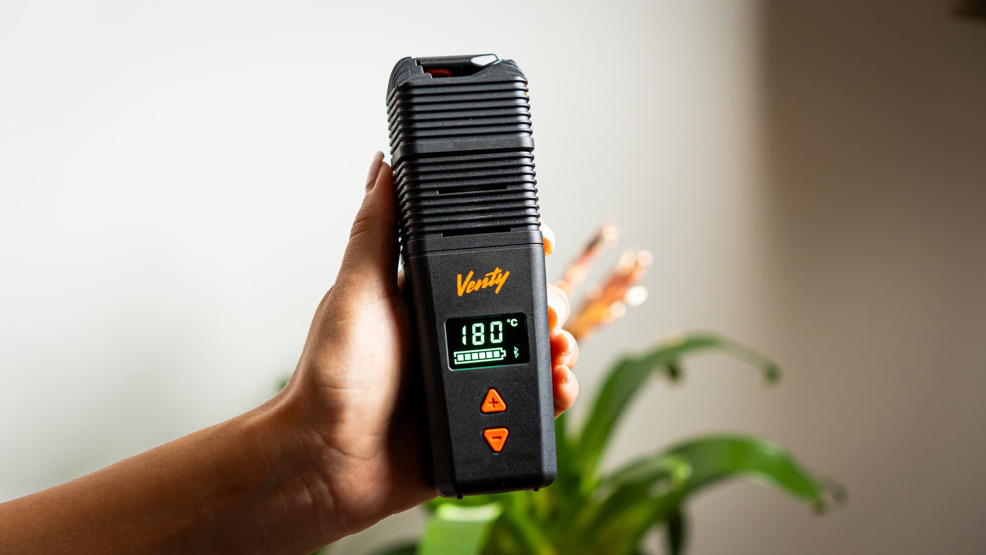 Venty vaporizer in hand with OLED showing 185°C, hybrid heater icon visible on display